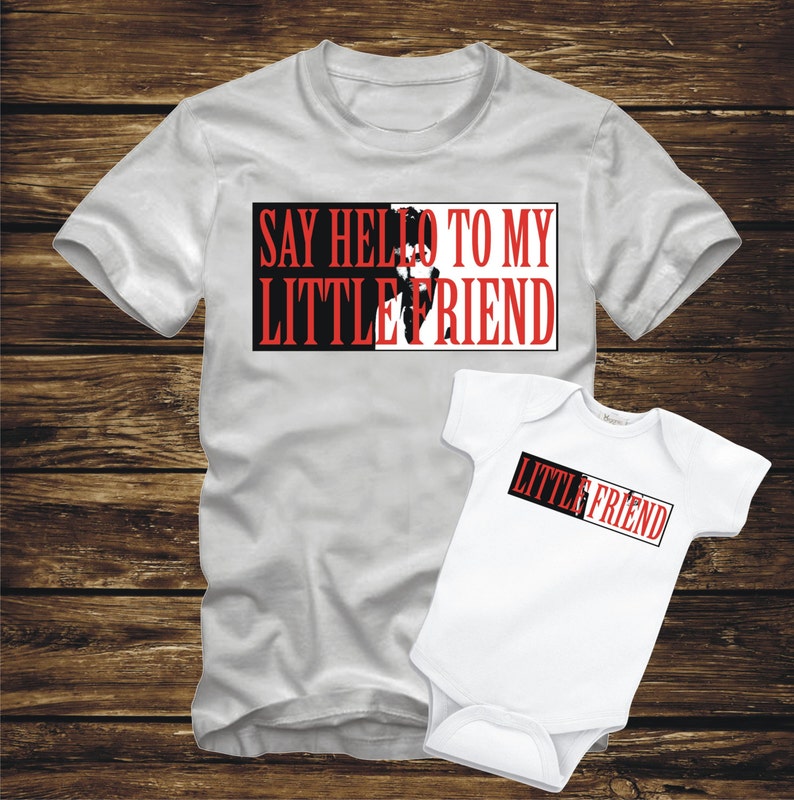 May include: A white t-shirt with the text "Say Hello To My Little Friend" in red and black. A white baby onesie with the text "Little Friend" in red and black.
