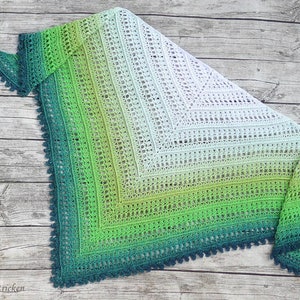May include: A green, blue and white crocheted shawl with a lacy pattern and a scalloped edge.