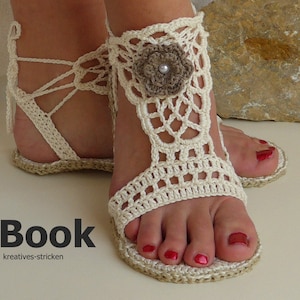 Peut inclure: Sandales en crochet blanc avec un embellissement floral sur la sangle de la cheville. Les sandales ont une semelle en jute et sont attachées avec des lacets.
