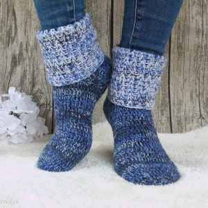 Könnte beinhalten: Ein Paar blaue und weiße gehäkelte Socken mit einem Umschlagbund. Die Socken sind aus einem melierten Garn gefertigt und haben ein strukturiertes Stichmuster.