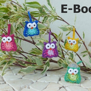 Könnte beinhalten: Fünf gehäkelte Eulen-Schlüsselanhänger in verschiedenen Farben, darunter blau, rosa, lila, gelb und grün, die an einem Zweig hängen. Die Eulen haben schwarze Augen und Schnäbel. Das Bild enthält den Text "E-Book".
