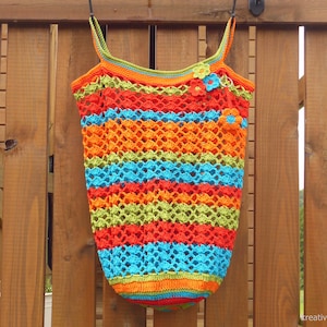May include: A colourful crocheted bag with a striped pattern in orange, red, blue, and green. The bag has two straps and is decorated with small crocheted flowers.