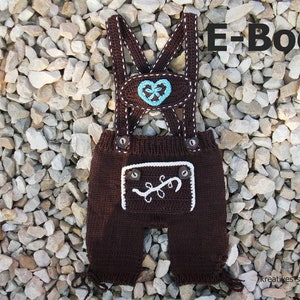 Könnte beinhalten: Braune gestrickte Baby-Latzhose mit Trägern, mit einem türkisfarbenen Herz und weißen Stickereidetails. Die Latzhose hat eine Tasche mit weißer Stickerei und Knopfverschlüssen. Der Text "E-Book" ist sichtbar.
