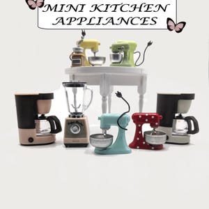 Könnte beinhalten: Miniatur-Küchengeräte in verschiedenen Farben, darunter eine Kaffeemaschine, ein Mixer und Küchenmaschinen. Der Text "MINI KITCHEN APPLIANCES" ist über den Produkten zu sehen. Die Geräte sind auf einer weißen Oberfläche angeordnet.