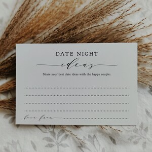 May include: A white card with the text "DATE NIGHT ideas" in black script. The card prompts users to share date ideas for a couple, with lines for writing and the words "love from" at the bottom. Dried plants are in the background.