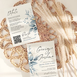 May include: Wedding invitation with a watercolor design of blue and gold leaves. The invitation is for Georgie & Joshua's wedding on Saturday, October 16, 20XX at four o'clock in the afternoon at The Copper Palace in Pine Forest Hills, Seattle. The reception will follow at Dancing Palace @ Pine Forest Hills.