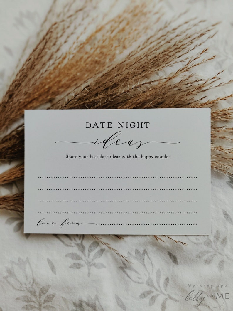 May include: A white card with the text "DATE NIGHT ideas" in black script. The card prompts users to share date ideas for a couple, with lines for writing and the words "love from" at the bottom. Dried plants are in the background.