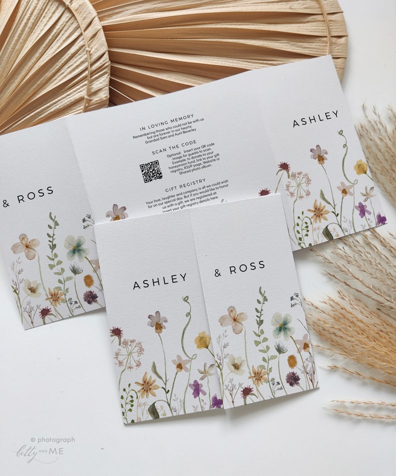 May include: A wedding invitation with a floral design. The invitation is folded in thirds and features the names Ashley and Ross. The invitation also includes a QR code and the text "Scan the code" and "Gift Registry".