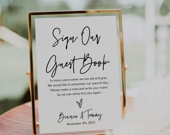 May include: A gold-framed sign with a white background and black text that reads "Sign Our Guest Book". The text continues with a message about remembering the special day and a request to write a name. The sign is signed "Bianca & Tommy" and the date "November 4th, 2023".