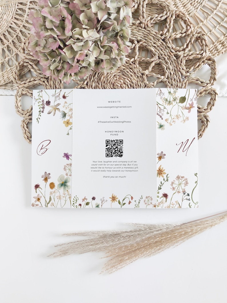 May include: A white wedding invitation with floral illustrations and text. The invitation includes a website, Instagram hashtag, and a QR code for a honeymoon fund. The design features botanical elements and the initials "B" and "M".