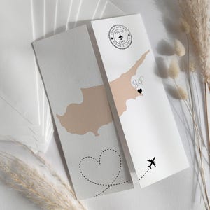 Puede incluir: Invitación de boda con un mapa beige de Chipre, un corazón punteado y un diseño de avión. La invitación incluye los nombres "Sammy & Patrick" y la fecha "JUL 13 20XX" con la ubicación "PROTARAS, CYPRUS".