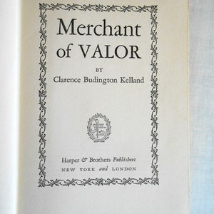 May include: Open book page featuring the title "Merchant of Valor" by Clarence Budington Kelland. The title is in a bold, serif font, framed by an ornate black and white border. The publisher's name and location are also visible.