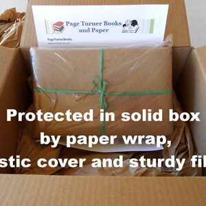May include: A brown cardboard box with a brown paper package inside. The package is wrapped in brown paper and secured with green tape. The box is filled with brown packing paper. The text "Protected in solid box by paper wrap, plastic cover and sturdy filler." is printed on the box.