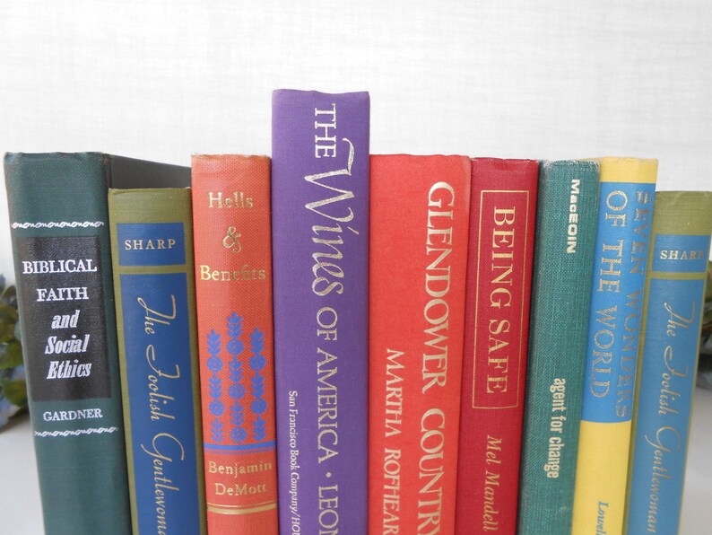 May include: A collection of ten vintage hardcover books with colorful spines. The titles include "The Wines of America", "Glendower Country", "Being Safe", "Of the World", "My Fair Ladies", "The Foolish Gentlewoman", "Hells & Benefits", "The Foolish Gentlewoman", "Sharp", and "Biblical Faith and Social Ethics".