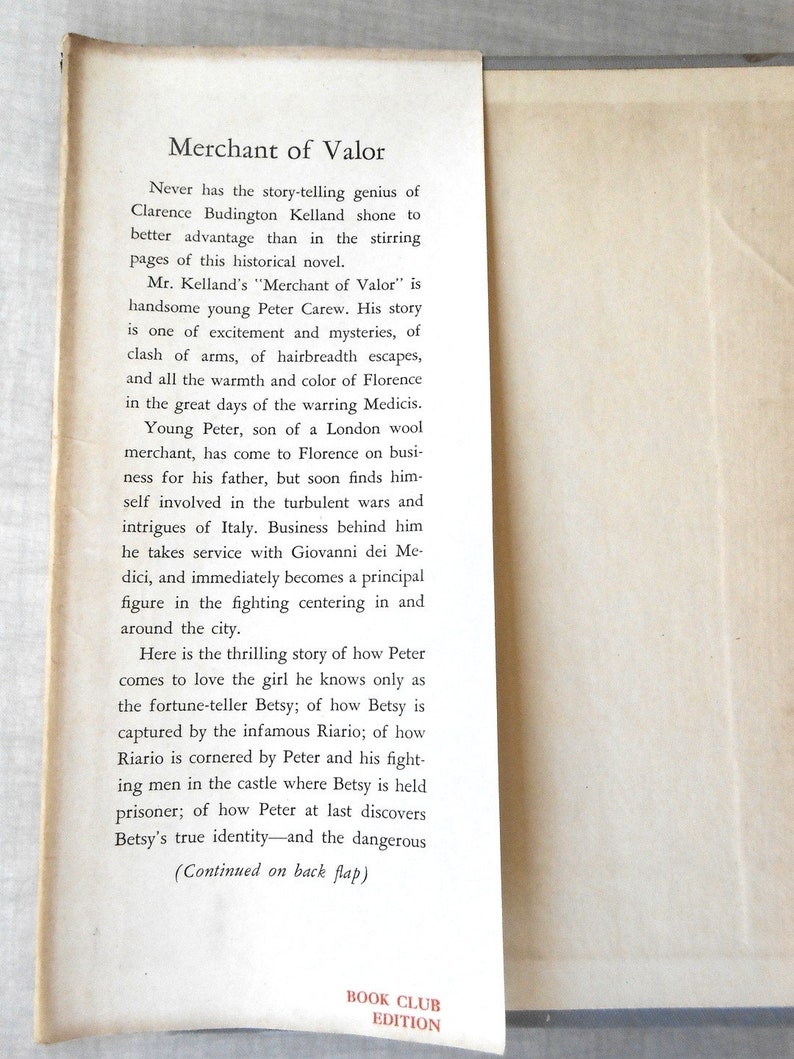 May include: Open book page with the title "Merchant of Valor" and descriptive text. The text describes the story of Peter Carew in Florence, Italy, and mentions the "Book Club Edition" at the bottom of the page.