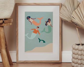 Puede incluir: Una ilustración enmarcada de tres sirenas nadando en un océano turquesa. Las sirenas tienen diferentes tonos de piel y colores de cabello. Una sirena lleva una blusa naranja, otra lleva una blusa verde y la tercera lleva una blusa rosa. Un pez verde nada debajo de las sirenas.