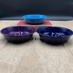 May include: A set of three ceramic mugs with a speckled, matte finish. The mugs are in shades of cream, light gray, and dark gray. Each mug has a simple, minimalist design and a rounded handle. The mugs are suitable for coffee, tea, or other beverages.