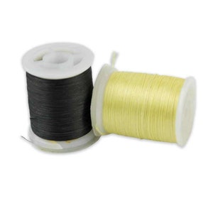 May include: Two spools of thread, one black and one yellow, are on a white background.