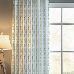 May include: A pair of white curtains with green and blue vertical stripes and a floral pattern. The curtains are hanging in a window with a wooden frame.
