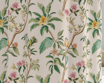 May include: A beige shower curtain with a floral pattern featuring pink and yellow flowers, green leaves, and small blue birds. The curtain is hanging in a bathroom with a white bathtub and a white tiled wall.