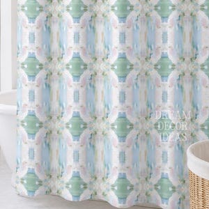 May include: A shower curtain featuring a repeating vertical pattern of soft watercolor-style brushstrokes in shades of light blue, sage green, and pale pink on a white background. The text DREAM DECOR IDEAS is printed in the lower right corner.
