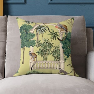 May include: A yellow cushion with a tropical print featuring monkeys and palm trees. The cushion has a white border and a white and grey archway design.