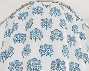 May include: A white shower curtain with a repeating pattern of blue stylized floral designs.