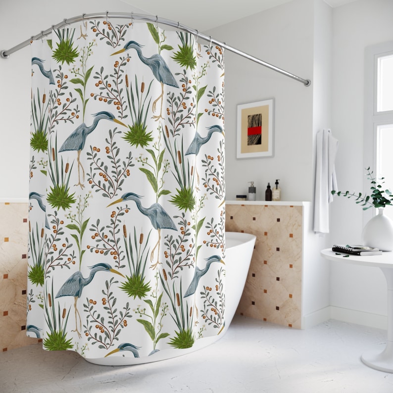May include: White shower curtain with a repeating pattern of blue herons, green reeds, and brown berries.
