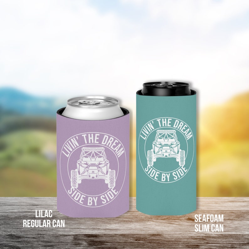 Op de afbeelding: Twee ge&iuml;soleerde drankenhouders, &eacute;&eacute;n lila en &eacute;&eacute;n zeegroen, met een witte afbeelding van een side-by-side voertuig en de tekst "Livin' the Dream Side by Side".