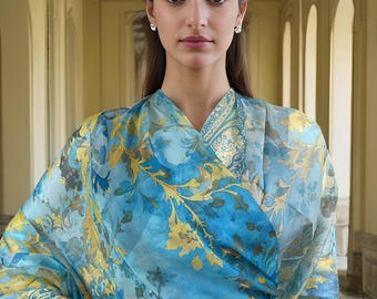 May include: A woman wearing a blue and yellow floral patterned scarf. The scarf is sheer and has a delicate design.