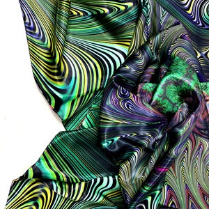 May include: A green, black and yellow patterned fabric with a swirling, abstract design. The fabric is made of a silky material and has a smooth texture.