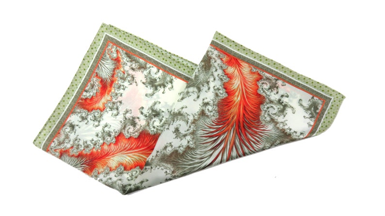 May include: A folded pocket square with a white background. The pocket square features a detailed design with red, gray, and white patterns. The edges are bordered with a green dotted pattern.