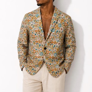 May include: A single-breasted blazer featuring a vibrant floral pattern in shades of orange, yellow, blue, and white on a light background. The jacket has a notched lapel, long sleeves, and a single dark button closure at the center front.