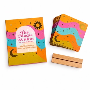 May include: A deck of cards and box set with the text "The Magic Within" in a retro design. The box and cards feature a colorful design with a sun, moon, stars, and wavy lines. A wooden card holder is also included.