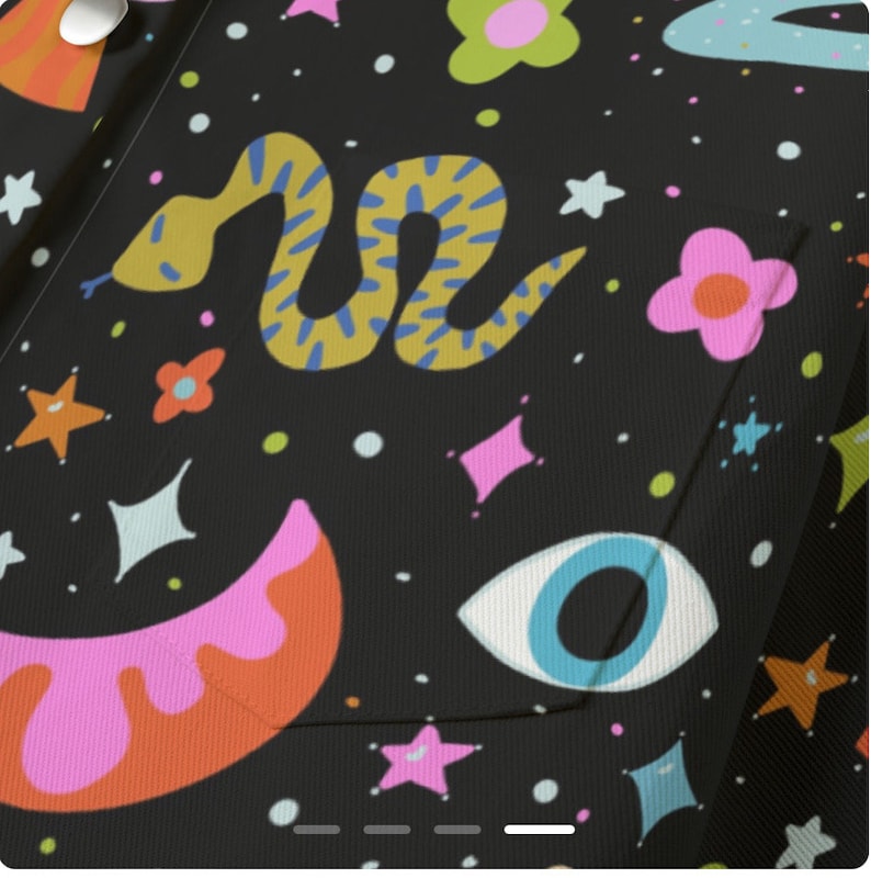 May include: Black fabric with a colorful, whimsical pattern. The design includes a yellow snake with blue markings, pink flowers, stars, and an eye. The fabric has a pocket.