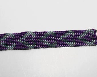 Può includere: Un braccialetto con perline viola e argento con una chiusura argentata.