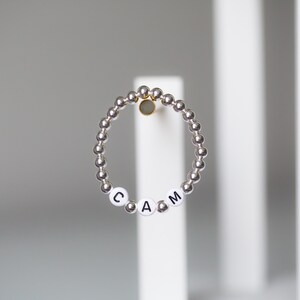 Black letters on white beads WITH 4mm metallics between ELASTIC