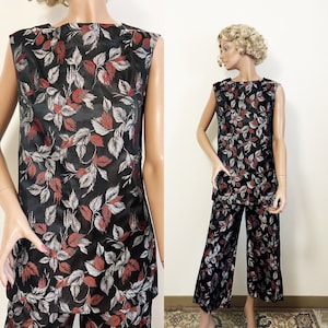 May include: A black sleeveless top and matching wide-leg trousers set. The fabric has a repeating pattern of red, white, and grey leaves. The outfit is displayed on a mannequin.