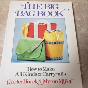 May include: The Big Bag Book cover featuring illustrations of various bags: a red duffel, a green satchel, and a yellow drawstring bag. The book's title is in large, stylized letters, with the subtitle "How to Make All Kinds of Carry-alls" and author names.