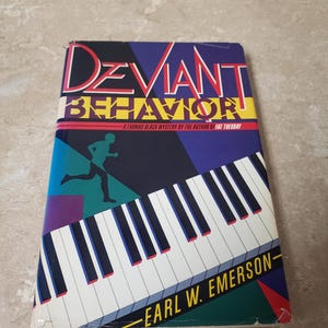 May include: A book cover with a colorful abstract design featuring a piano keyboard and a running figure. The title of the book is "Deviant Behavior" and the author is Earl W. Emerson.