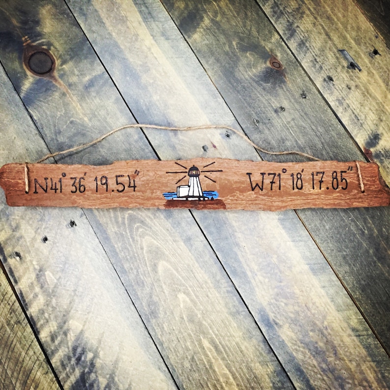 May include: A wooden sign with a lighthouse illustration and the coordinates "N41&deg; 36' 19.54" and "W71&deg; 18' 17.85" engraved on it.