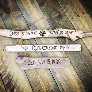May include: A rustic wooden sign with the text "THE RUTHERFORD FAMILY Est. Nov 15, 1969" and coordinates "N30° 13' 24.33" and "W85 38 03.40".