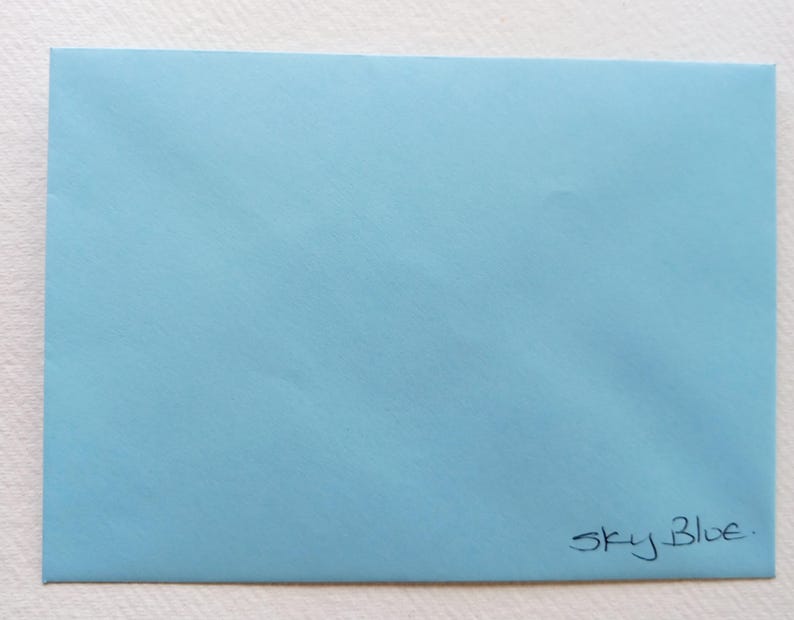 May include: A light blue envelope with the text "Sky Blue." written in black ink.