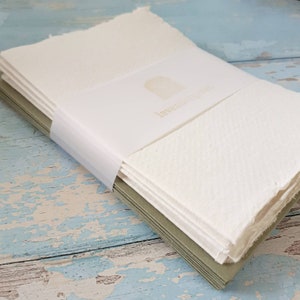 May include: A stack of white, textured paper cards with a white envelope and the text "lavender paper" printed on the envelope.