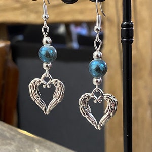 Silver dangling heart earrings with angel wings, heart-shaped feathers and blue-reflecting pearls