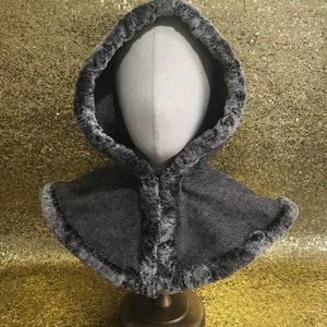May include: A grey hooded neck warmer with a herringbone pattern and a faux fur trim.