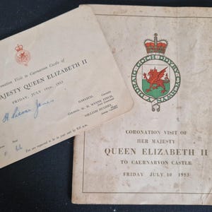 May include: Two aged documents relating to the Coronation Visit of Her Majesty Queen Elizabeth II to Caernarvon Castle, dated July 10, 1953. One features a red crest and a handwritten signature.