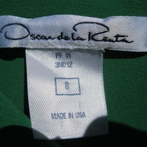 May include: White tag with black text reading "Oscar de la Renta" and "Made in USA". The tag also has the numbers "PF 11 34012" and "8" printed on it.