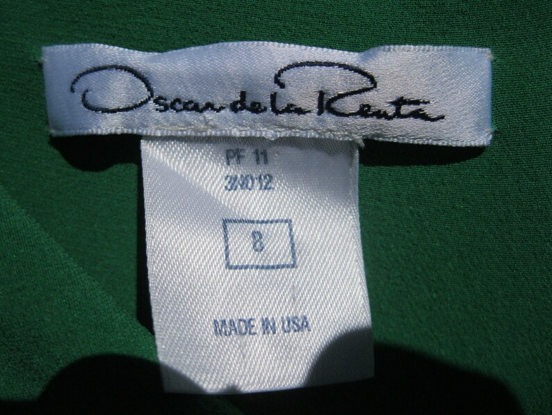 May include: White tag with black text reading "Oscar de la Renta" and "Made in USA". The tag also has the numbers "PF 11 34012" and "8" printed on it.