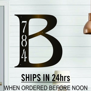 May include: Dark bronze metal house number sign with the letter B and the numbers 784. The sign is mounted on a white wall. The text "SHIPS IN 24hrs WHEN ORDERED BEFORE NOON FOR 11/27-12/25 SEE APPROX SHIP & DELIVERY DATE FOR YOUR ZIP CODE BELOW BEFORE ORDERING" is printed below the sign.
